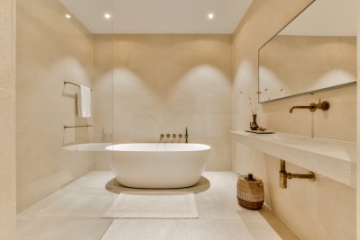 Minimalistische badkamer met bad en messing details