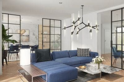 Lichte woonkamer met een blauwe bank en stoelen